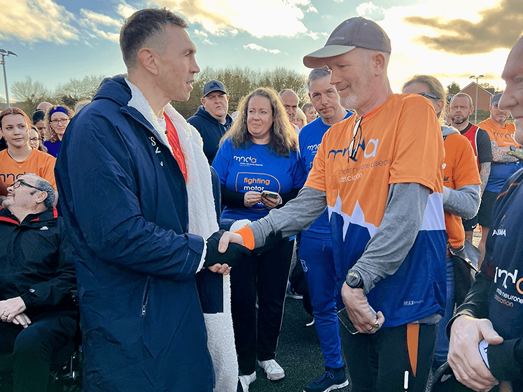 Kevin Sinfield shaking hands with a fundraiser | MND